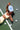 Woman lying on a pickleball court with a paddle and balls